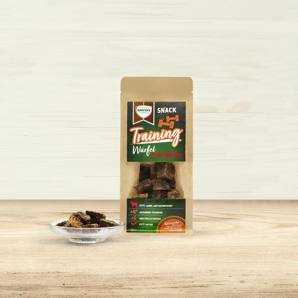 Trainings Würfel vom Lamm Verpackung von BARFER'S. Daneben steht ein Glasschälchen gefüllt mit luftgetrockneten Lamm-Leckerli.