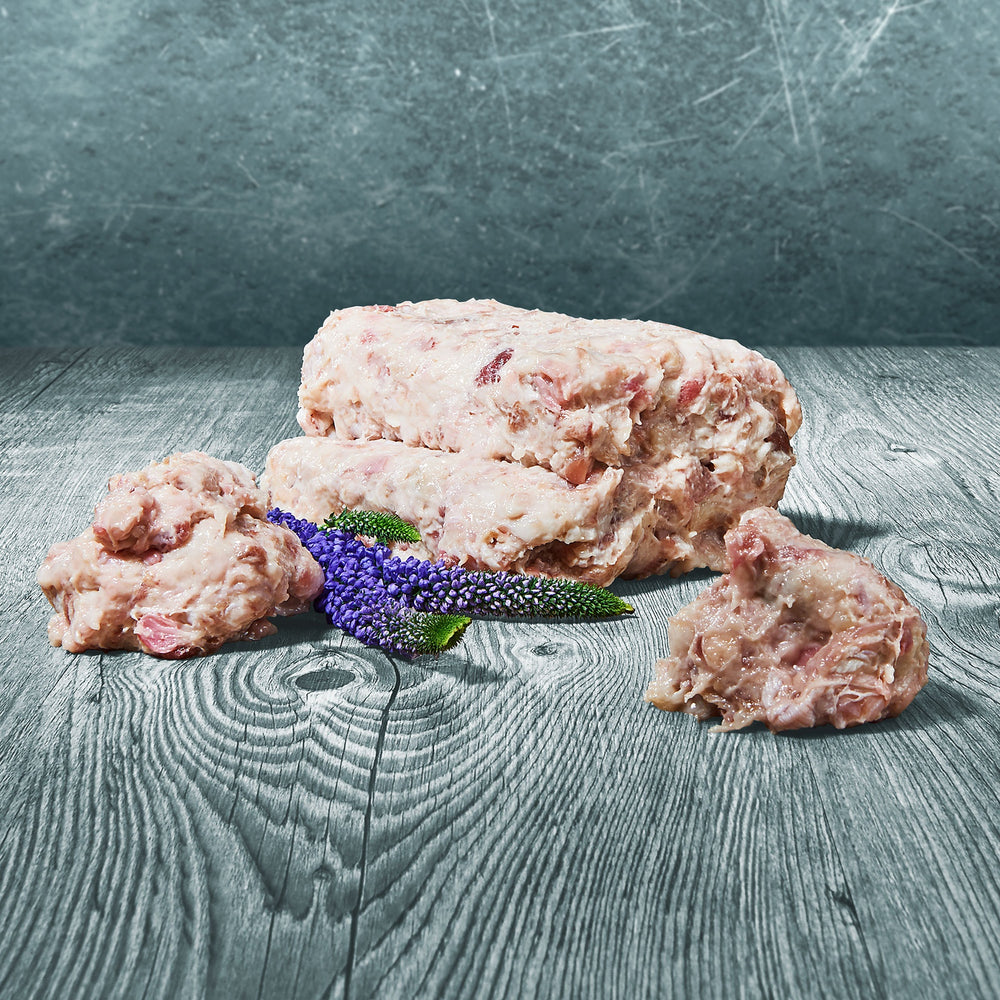 Gefrorene Blöcke Pferdefett zum Barfen auf grauer Holzoberfläche mit lila Blüten als Dekoration