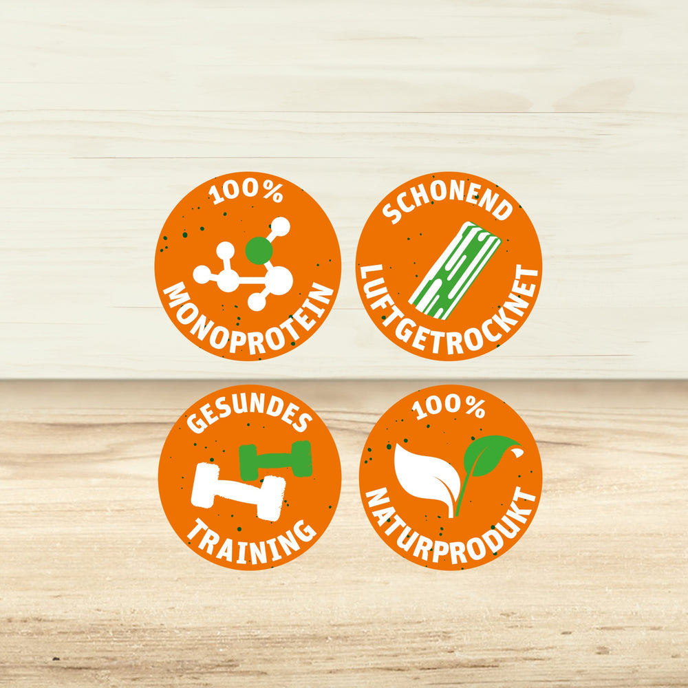 4 Sprechblasen mit den Texten "100% MONOPROTEIN", "SCHONEND LUFTGETROCKNET", "GESUNDES TRAINING" und "100% NATURPRODUKT".
