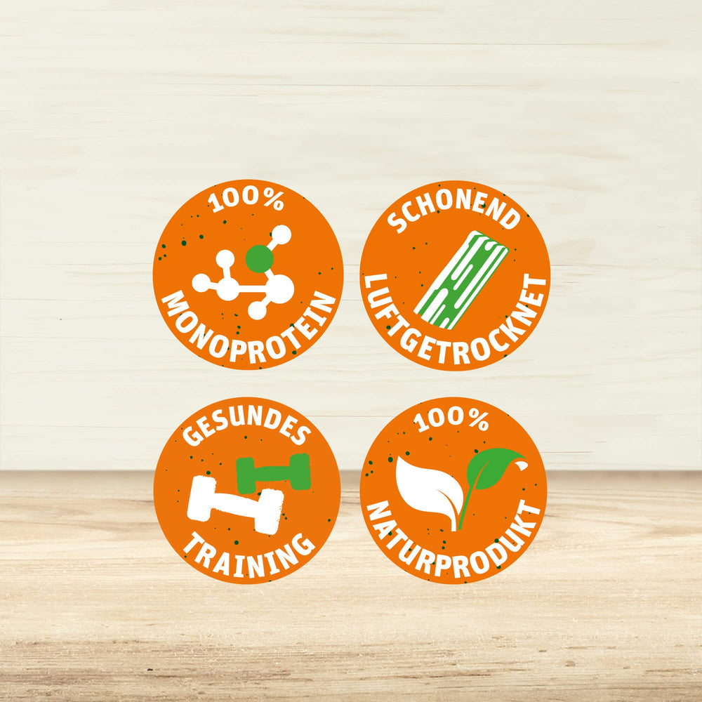 4 Sprechblasen mit den Texten "100% MONOPROTEIN", "SCHONEND LUFTGETROCKNET", "GESUNDES TRAINING" und "100% NATURPRODUKT".