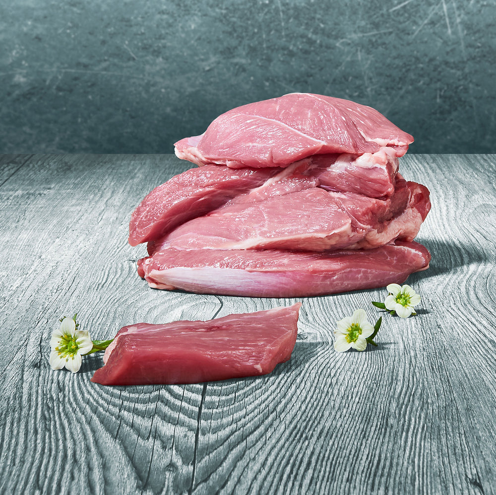 Stücke von Lammmuskelfleisch auf Holztisch – naturbelassenes Fleisch als hochwertige Proteinquelle für die BARF-Ernährung