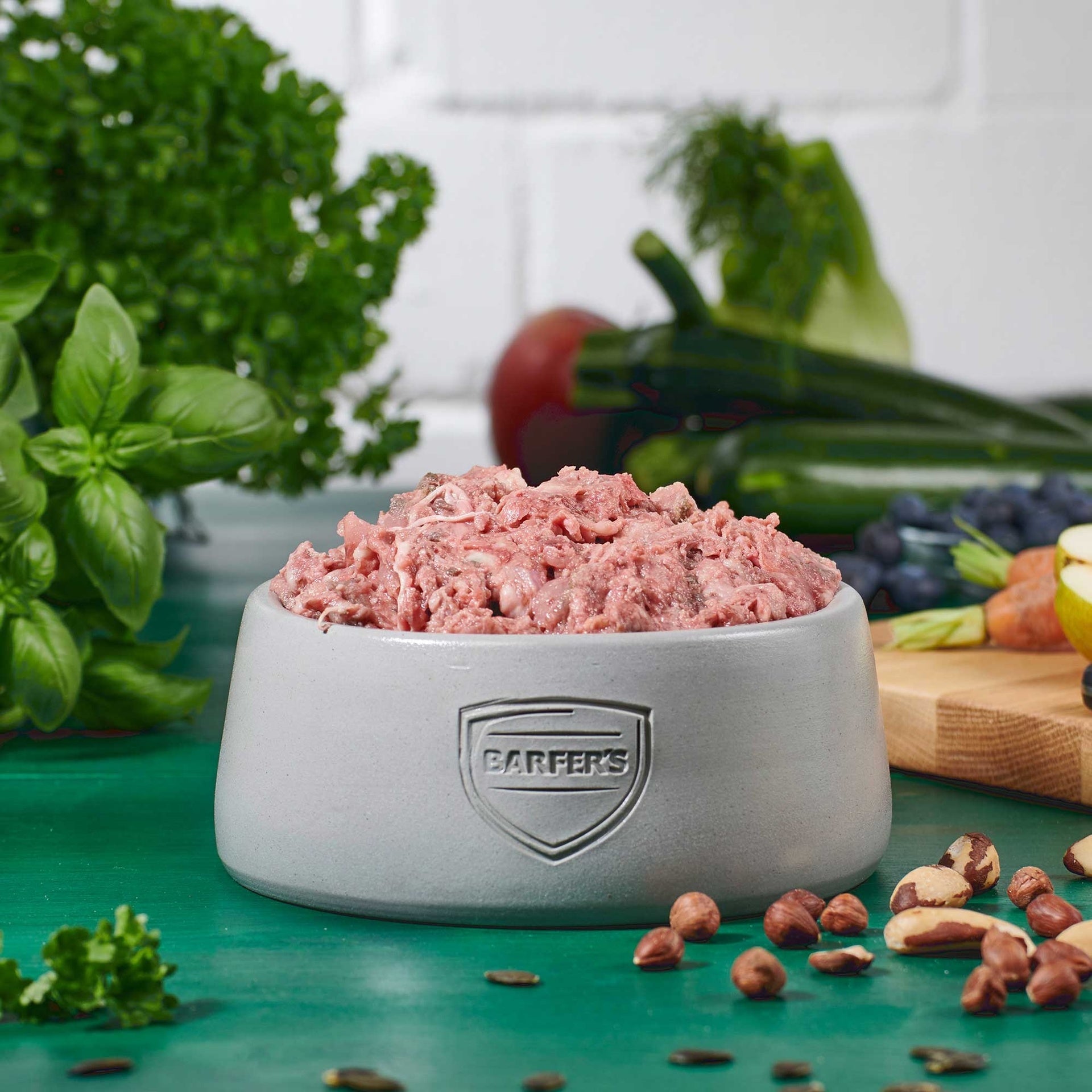 Gefüllter Futternapf mit BARFER’S Fleisch-Mix Rind – artgerechtes BARF-Futter für Hunde aus Rindfleisch, Hühnerhals, Rinderpansen, Blättermagen, Rinderherz, Rinderleber, Rinderniere und Rindermilz, dekoriert mit frischem Gemüse und Nüssen