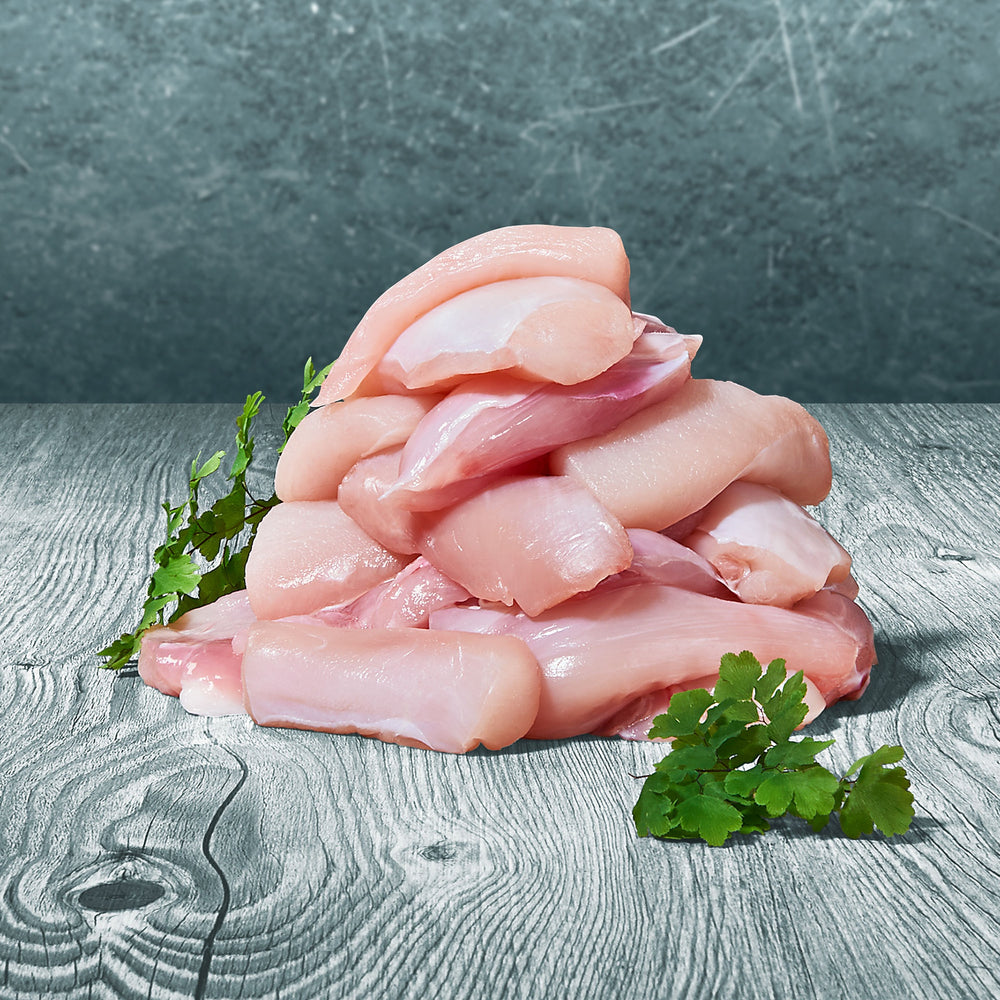 Rohe Stücke BARF-Kaninchenmuskelfleisch auf Holztisch mit grüner Blattdeko dekoriert