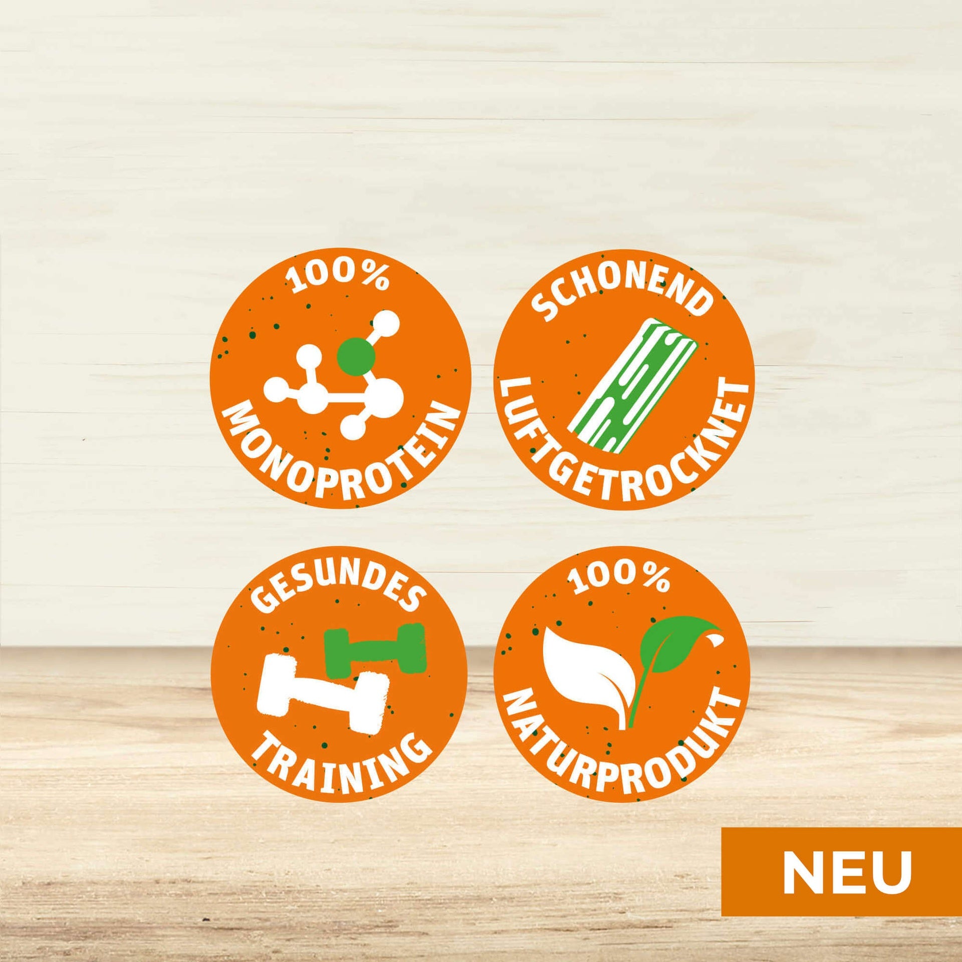 4 Sprechblasen mit den Texten "100% MONOPROTEIN", "SCHONEND LUFTGETROCKNET", "GESUNDES TRAINING" und "100% NATURPRODUKT". Darunter steht farblich unterlegt "NEU".