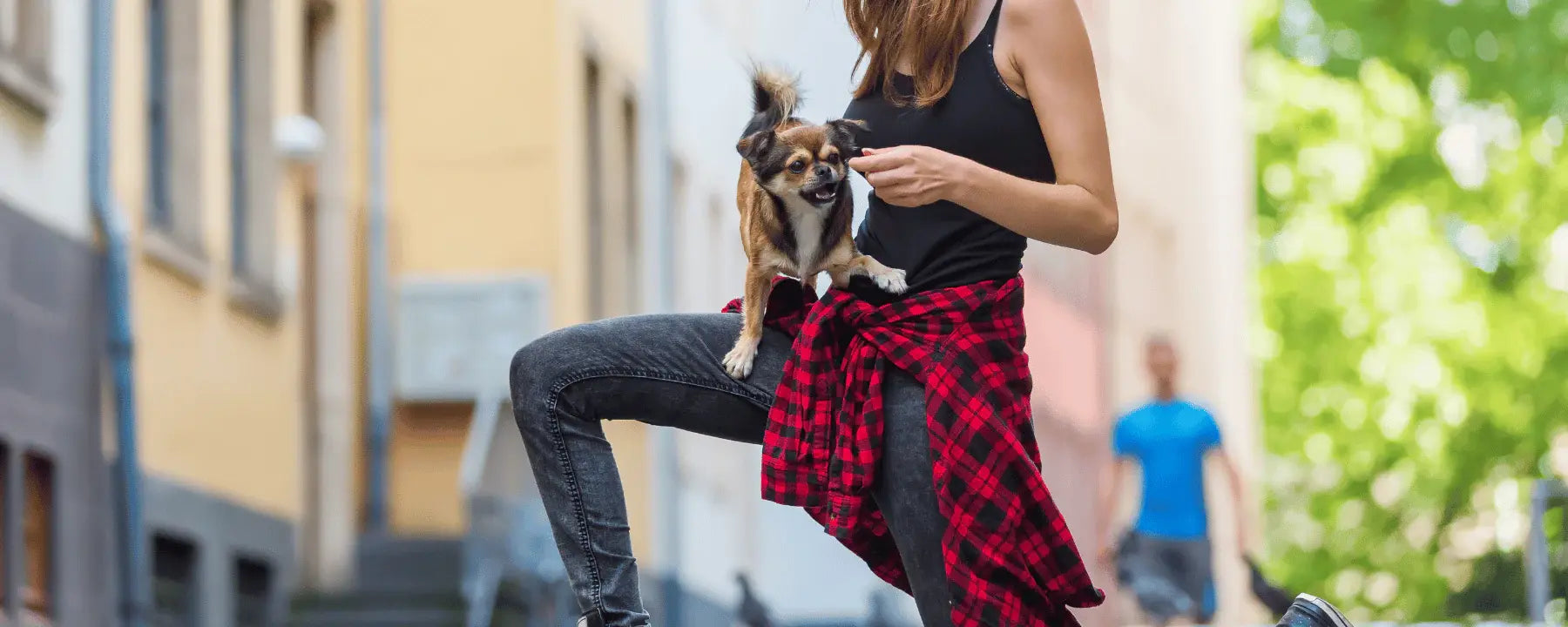 Eine tanzende Frau mit ihrem Hund auf dem Arm
