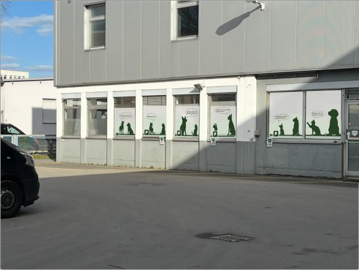 Kundenparkplatz mit Parkflächen vor dem BARFER'S Hofladen Marienfelde Berlin mit Hund- und Katzenmotiven an den Fensterfronten