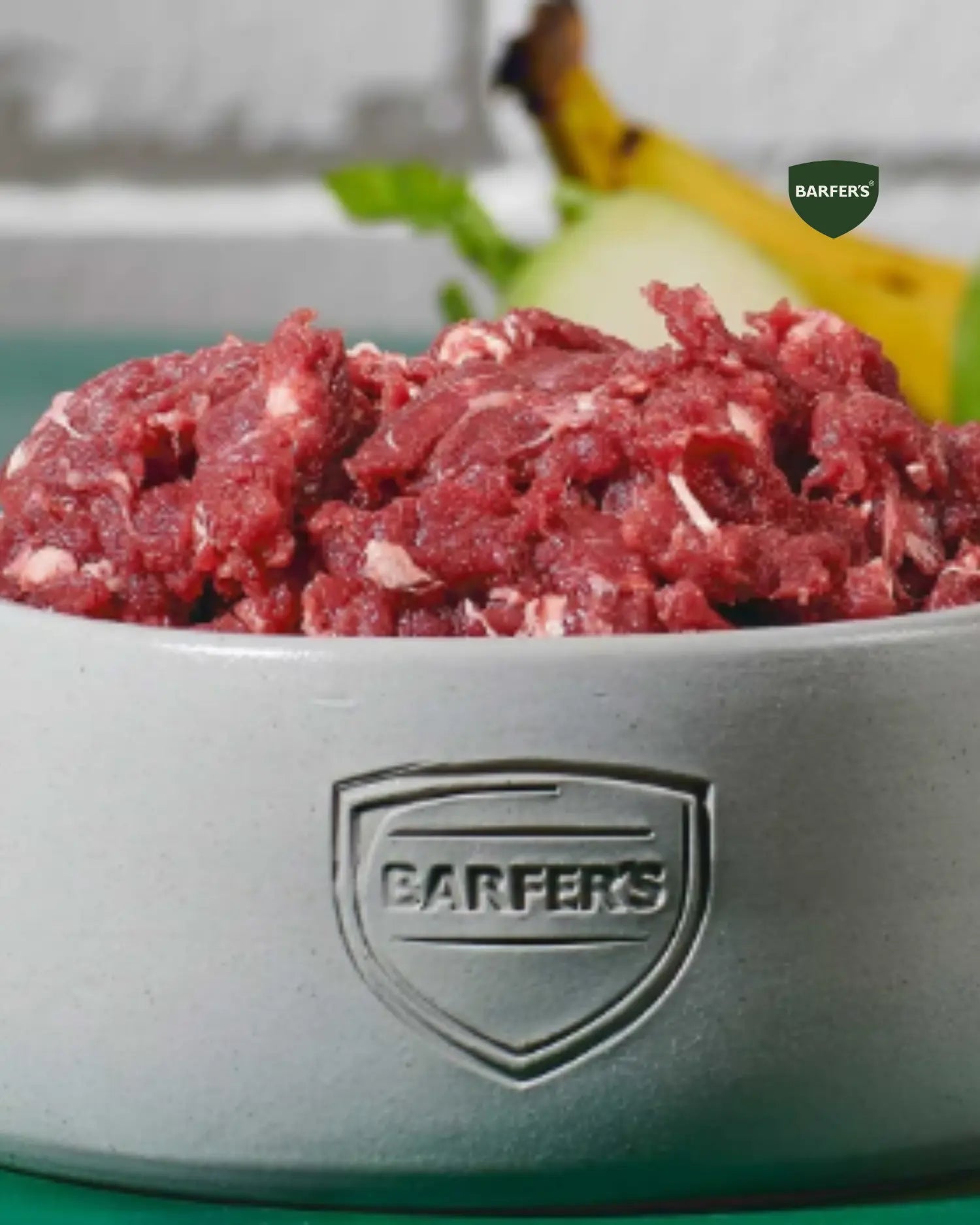 Napf mit rohem Rindfleisch für Hunde – typisches Muskelfleisch mit Sehnen und Fett als Bestandteil einer BARF-Mahlzeit