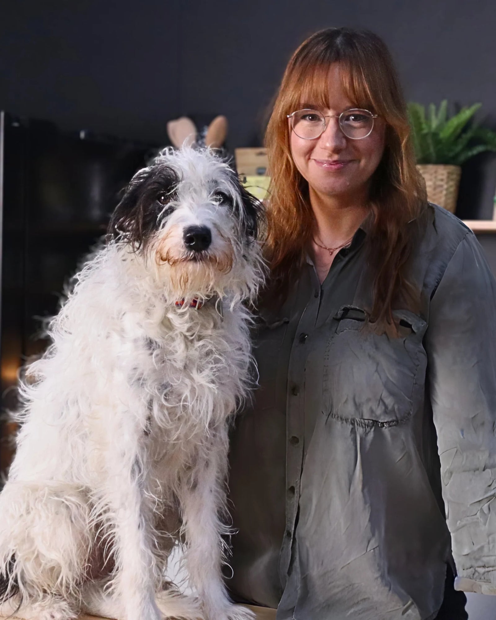 BARF-Ernährungsberaterin Carolin steht in der Küche und ihr Hund Fragola sitzt vor ihr.