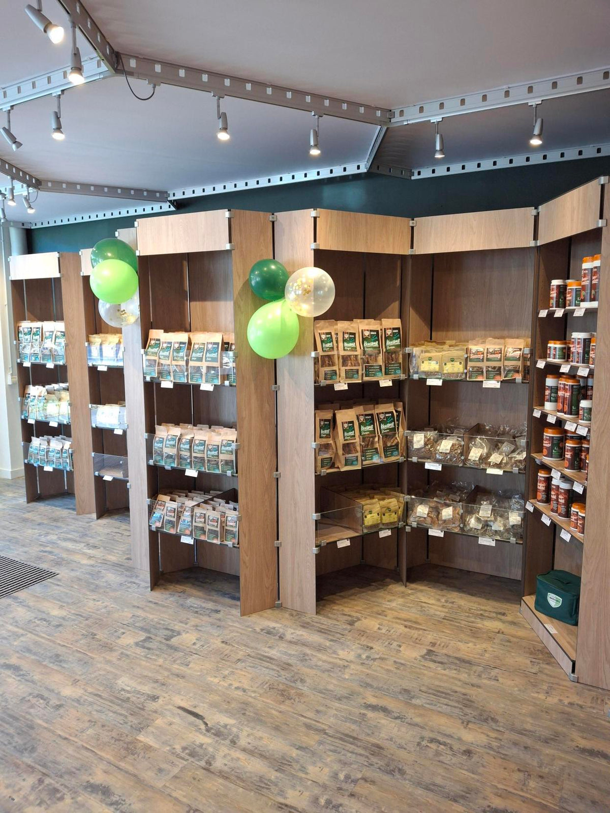 Wand voller Holzregale mit luftgetrockneten Leckerli für Hunde und Katzen sowie BARF-Zusätzen im BARFER'S Store in Hamburg-Barmbek.