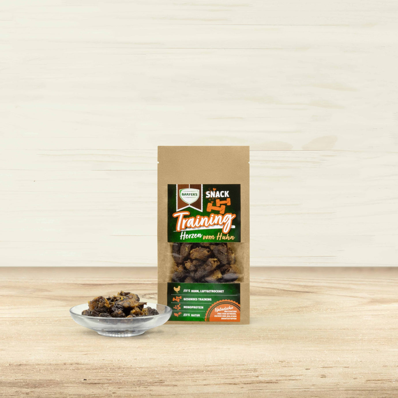 Herzen vom Huhn Training Verpackung von BARFER'S . Daneben steht ein Glasschälchen mit luftgetrockneten Hühnerherzen.